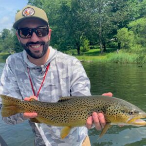 Cross Current Insurance's Dan Phelan showing the brown trout he caught fly fishing.