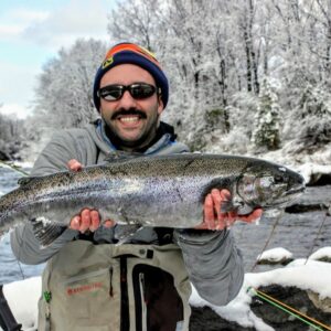 Cross Current Insurance Sales Manager Dan Phelan holding the steelhead he caught winter fly fishing.