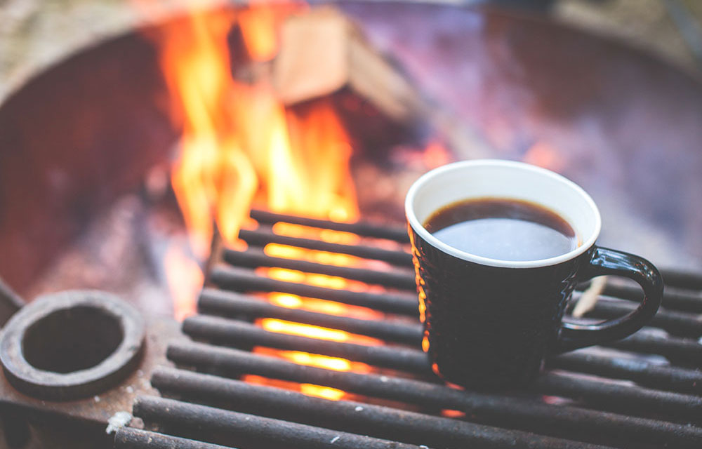 Morning coffee around the campfire at fly fishing lodge