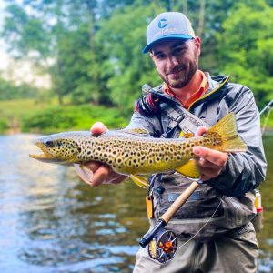 Pete Sconzo, Sales Associate with Cross Current displaying a brown trout on the Farmington River, CT