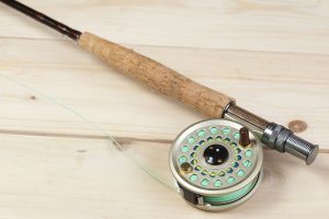 Fly fishing rod on wooden table