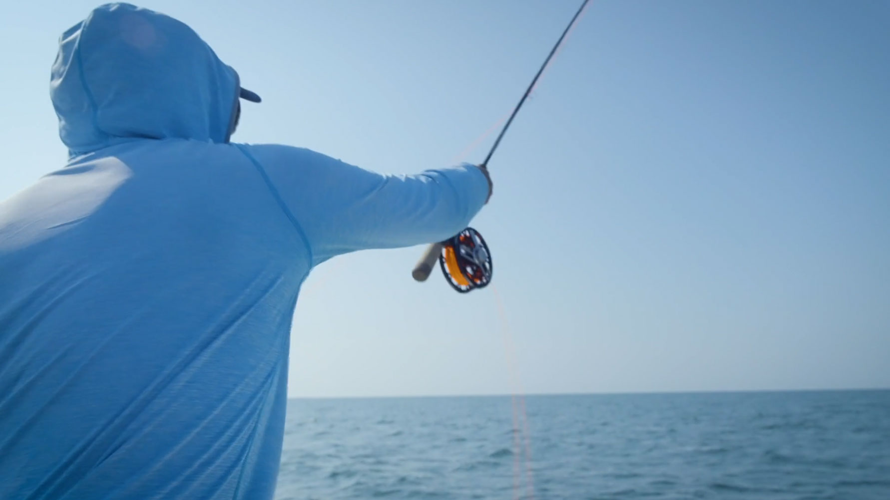 Fly fishing angler casting into the ocean