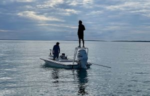 Fly fishing angler and a guide on a skiff in the ocean